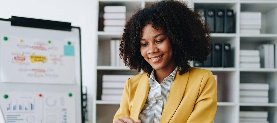 Business account working at computer with paper spreadheets