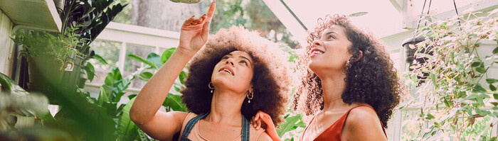 Two females in a greenhouse talking