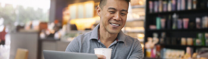 Man checking a mobile phone with laptop