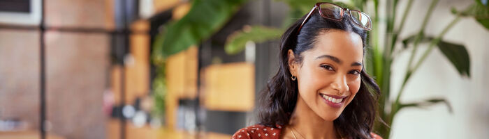 Young woman at computer smiling into camera